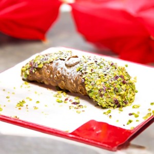 Sicilian cannoli covered with pistachio granules.