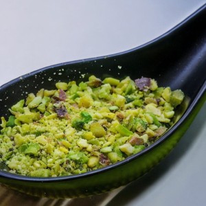 Pistachio granules on a black spoon